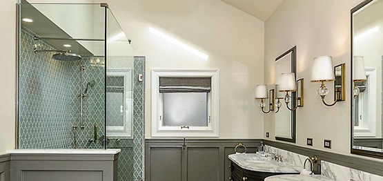 Functional stylish bathroom with glass-enclosed shower and two mirrors in Chicago
