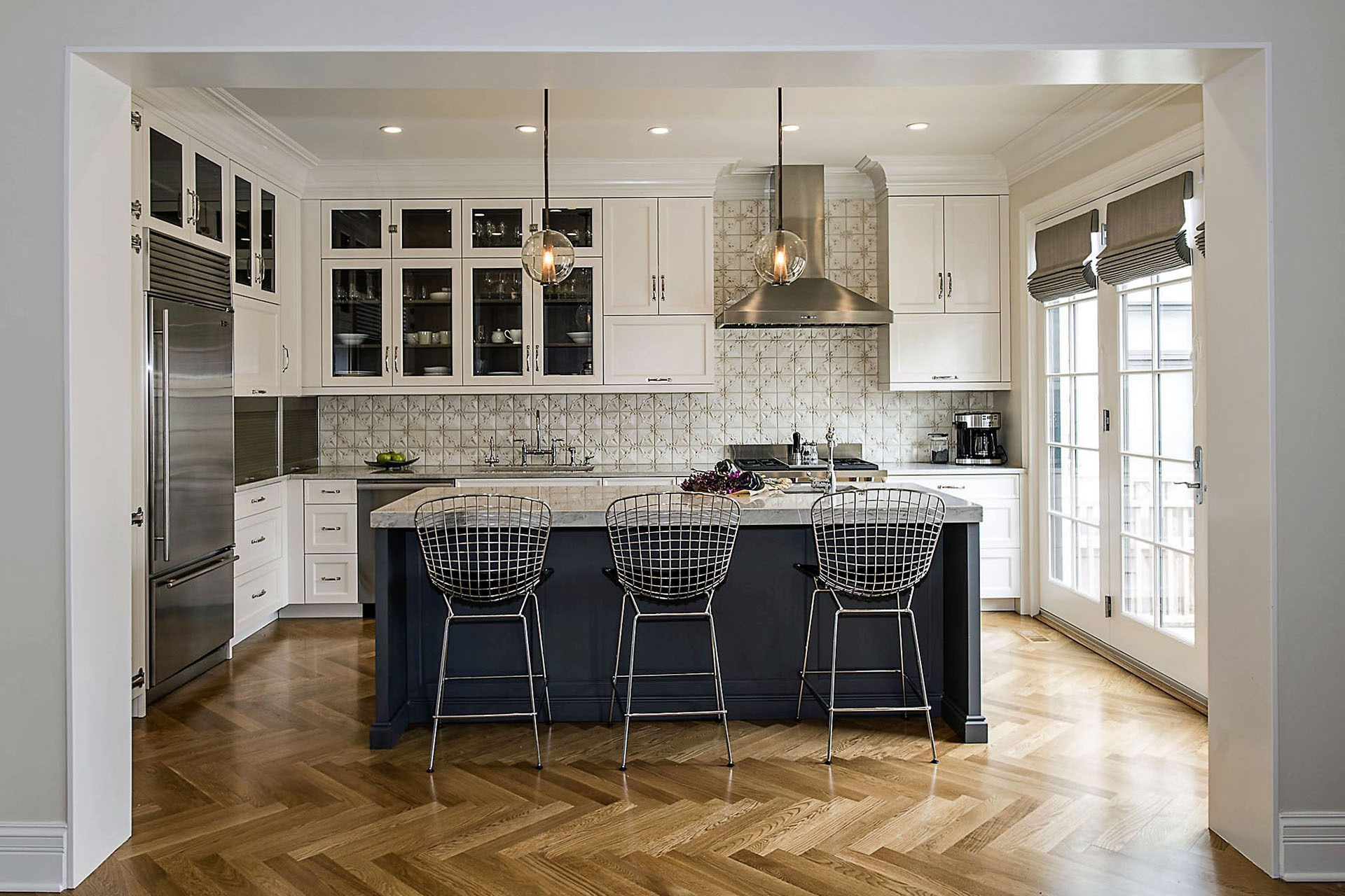 Spacious classically white kitchen design with island and three stylish bar chairs in Chicago