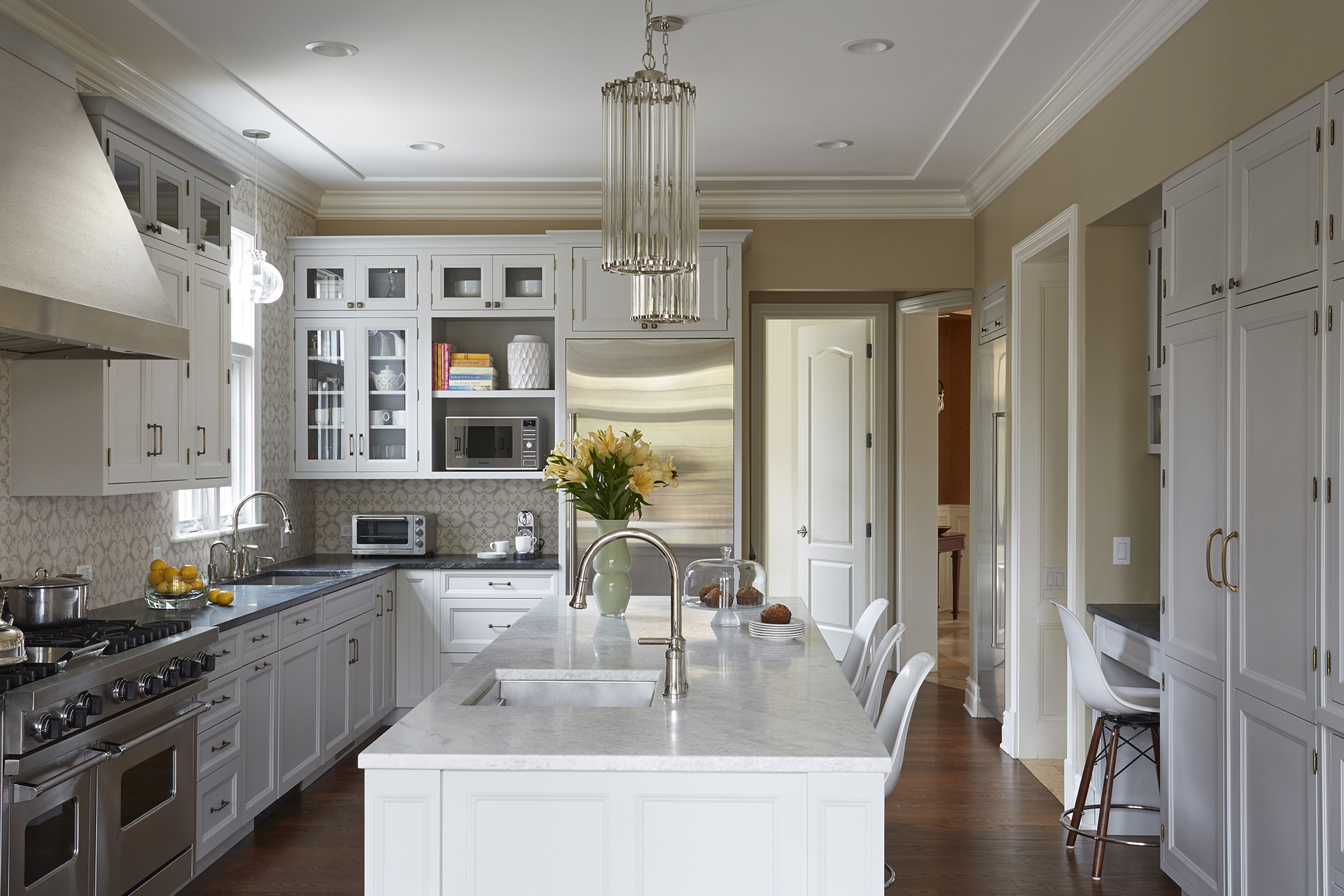 Luxury white kitchen furniture design with large island after remodeling in Winnetka