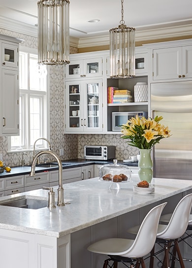 Stylish kitchen with white cabinets and modern white kitchen island in Winnetka