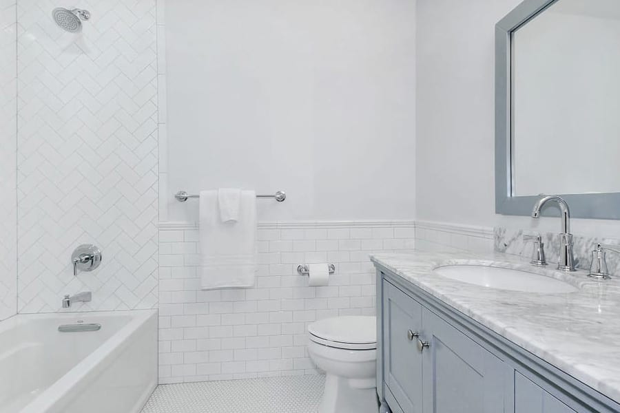 Kids bath design with white subway wainscotting and penny tile in Wilmette