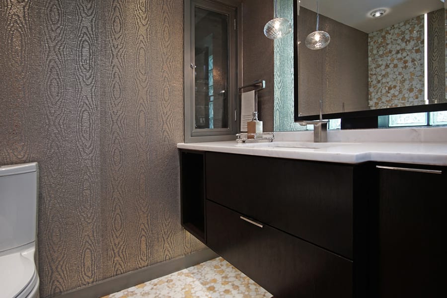Lake Forest bathroom design with dark brown finish, accent wallpaper, two tone floor tile