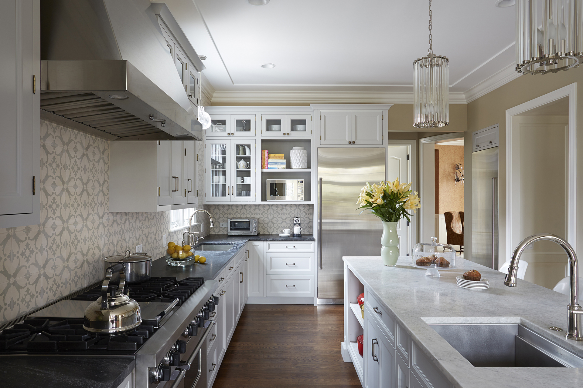 Impressive white kitchen design with large kitchen windows and wood flooring in Winnetka
