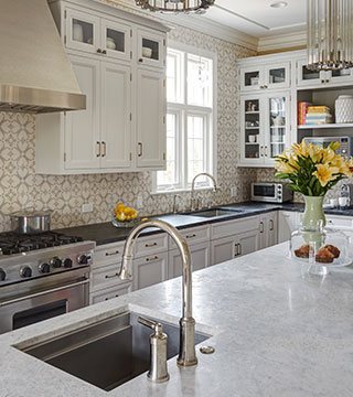 Stylish kitchen with white cabinets and modern white kitchen island in Winnetka